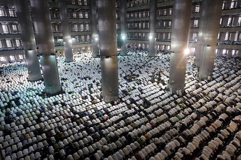 A big crowd at a mass prayer at Masjid Istiqlal in Jakarta yesterday. Ms Sylviana Murni and Mr Agus Harimurti Yudhoyono, backed by the Democratic Party, and Mr Anies Baswedan and Mr Sandiaga Uno, backed by the Gerindra Party, were among those who tur