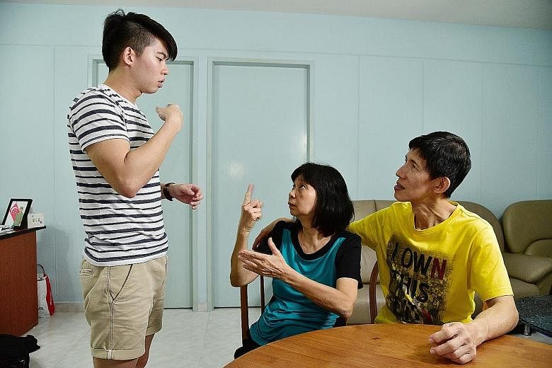 Mr Quek conversing in sign language with his parents, who missed his scholarship presentation ceremony because of their job schedules. He wants to create a device that can interpret sign language by detecting hand movements using a video camera and t