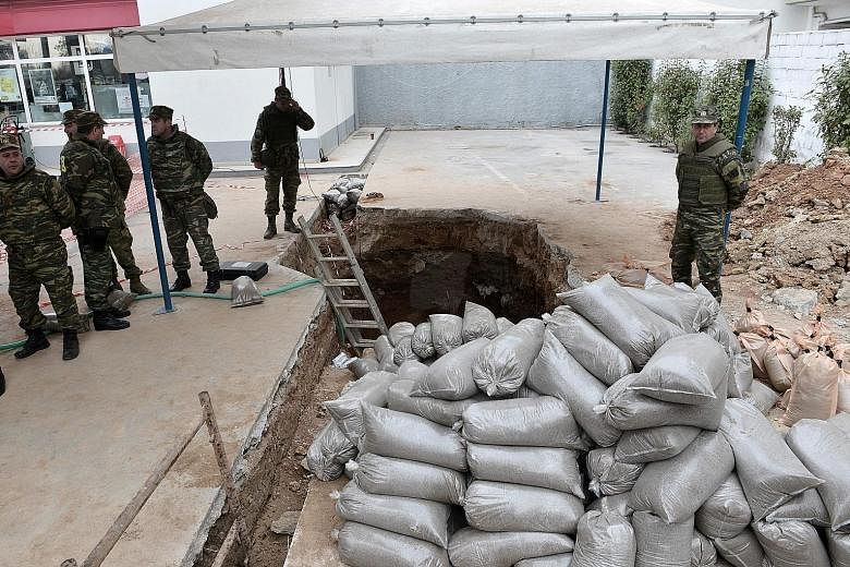 Greek military personnel at the site where a World War II bomb was discovered in Kordelio, Thessaloniki, before the bomb was deactivated yesterday. The explosive was uncovered during excavation works at a petrol station. Up to 72,000 residents were t