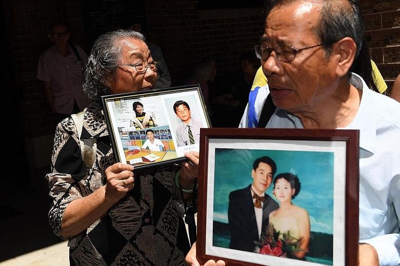 Xie being led away yesterday, after being found guilty of murdering five of his relatives. He plans to appeal. The parents of Mr Norman Lin with portraits of the slain family members outside the New South Wales Supreme Court in Sydney yesterday.