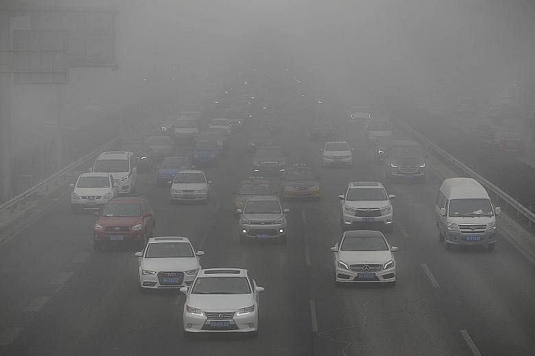 Vehicles travelling along a smog-filled road in Beijing yesterday. The Chinese capital issued a yellow alert against heavy air pollution from yesterday to tomorrow.