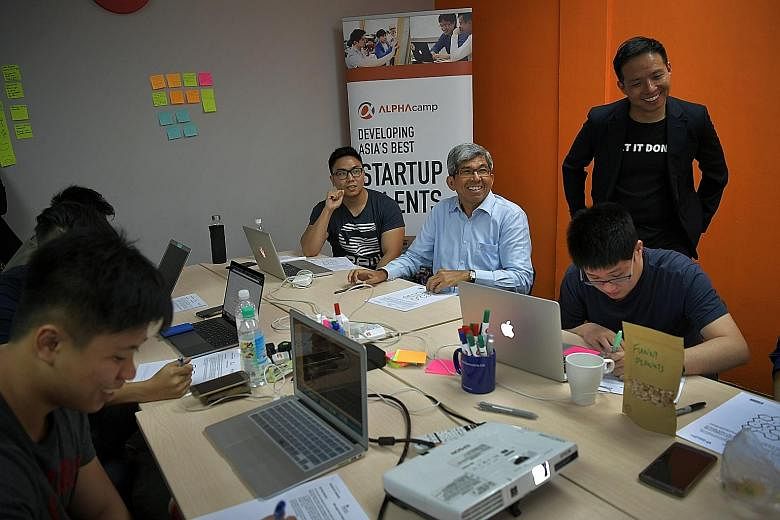 Dr Yaacob (second from left) at an Alpha Camp class with students (from left) Ashleigh Rhazaly and Ng Yao Min and the school's chief executive Bernard Chan (standing). The school equips students with skills to enter the information and communications