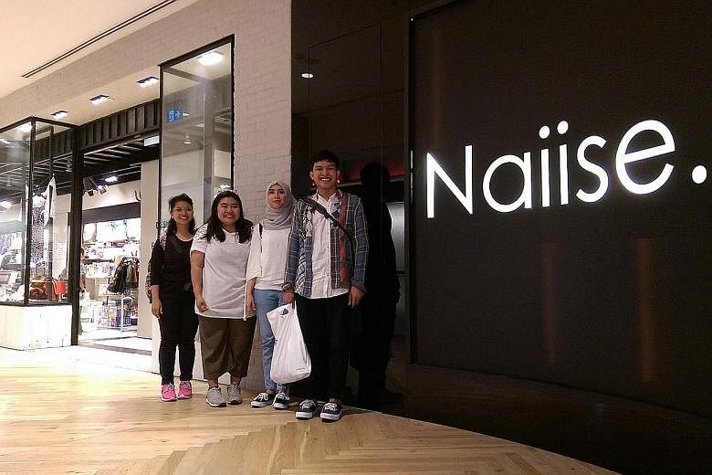 (From far left) Ms Ida Ayu Farina, 24; Ms Ari Suci, 23; Ms Lintang and Mr Radike outside the Naiise outlet in Orchard Gateway. The Indonesian visitors are here for goods made or designed in Singapore.