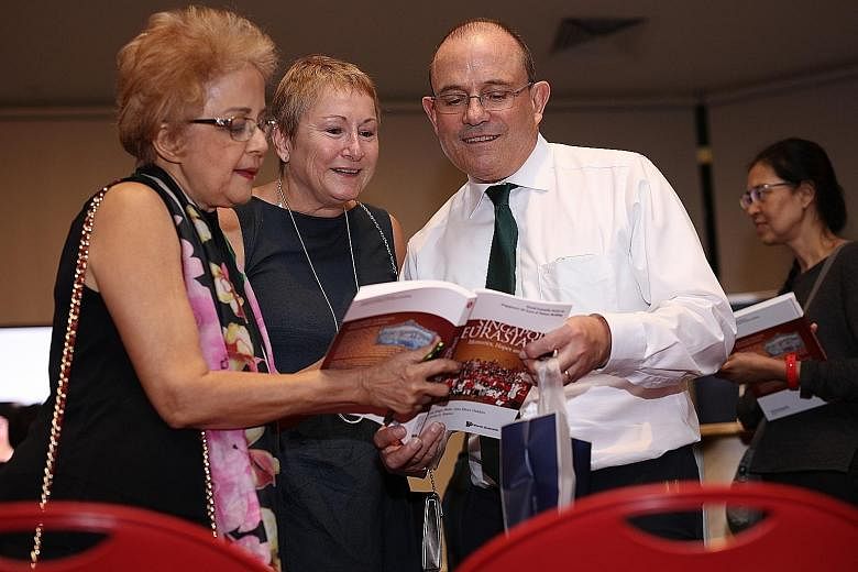 Eurasian Association member and contributing author Patricia De Souza (far left) browsing the book with Ambassador of Ireland Geoffrey Keating and his wife, Jane.