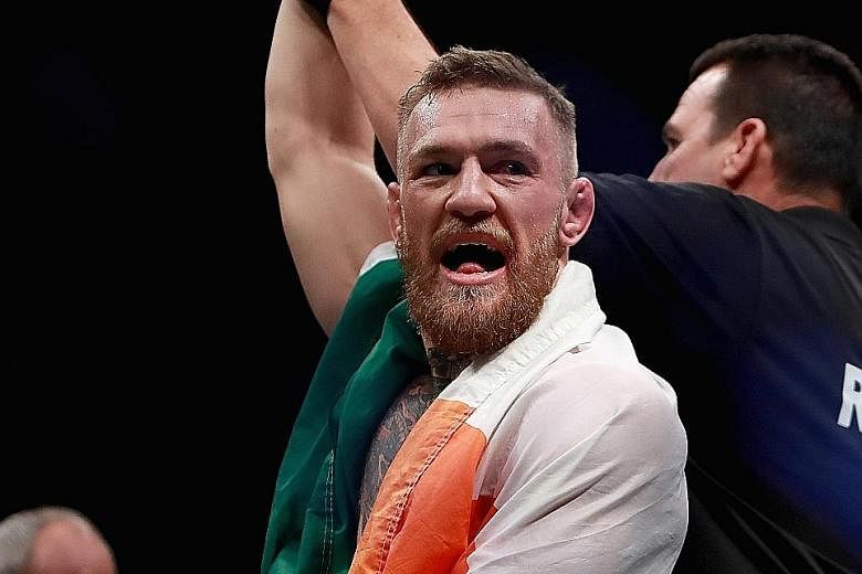 Conor McGregor celebrates his win over Eddie Alvarez in their lightweight championship bout at UFC 205. Following that victory, he became the first man to simultaneously hold UFC titles in two weight divisions.