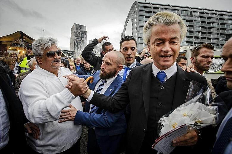 In this November 2015 file photo, Mr Geert Wilders (in suit) is seen distributing flyers to protest against accommodating refugees in Rotterdam.