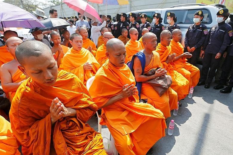 Buddhist monks chanting at Dhammakaya temple amid a massive security deployment yesterday. Prime Minister Prayut Chan-o-cha issued an order declaring the temple a controlled zone and authorised security forces to take control of any type of infrastru