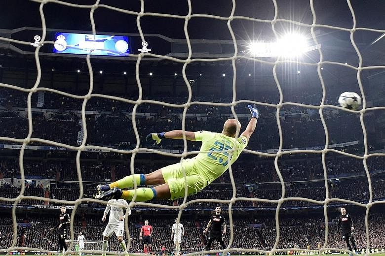 Napoli goalkeeper Pepe Reina makes a futile attempt to prevent Real Madrid's Casemiro from scoring in the Spanish side's 3-1 victory in their Champions League first-leg match in Madrid on Wednesday. Despite the win, Real coach Zinedine Zidane said th
