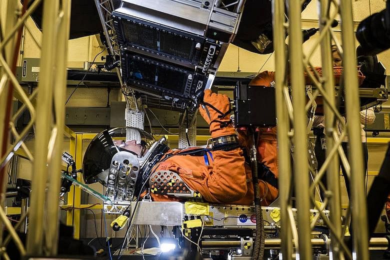 An engineer simulates conditions astronauts would face when the Orion launches, in a lab at Johnson Space Centre in Houston. Under current plans for the first flight, a crewless Orion capsule would spend three weeks in space.