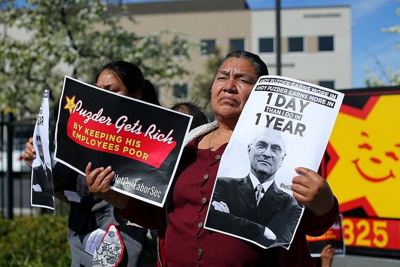 Fast-food workers in Anaheim, California, at an anti-Puzder protest on Monday. Mr Puzder's business record and character have come under attack from various groups.