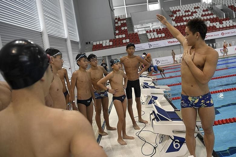 National swimmer Pang Sheng Jun showing how one's arm should be positioned in the backstroke at a clinic at the OCBC Aquatic Centre. The Singapore Swimming Association inked a four-year sponsorship deal with Liberty Insurance.