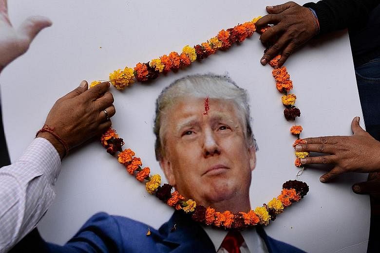 Right-wing activists of India's Hindu Sena party garlanding a poster of Mr Trump during an event in New Delhi on Jan 19, the day before his inauguration as US President.