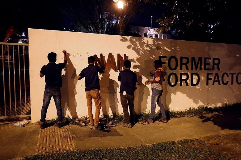 Workers removing the signage for the gallery at the Former Ford Factory in Upper Bukit Timah Road last night. Other signs carrying the old name have also been removed or covered.