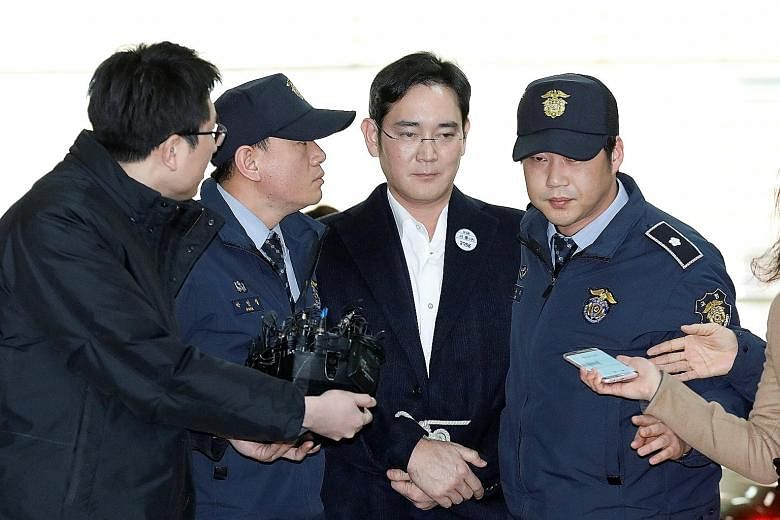 Samsung Group chief Lee arriving at the office of special prosecutors in Seoul yesterday. He was arrested a day earlier for his alleged role in a corruption scandal that has led to the impeachment of South Korean President Park Geun Hye, and he spent