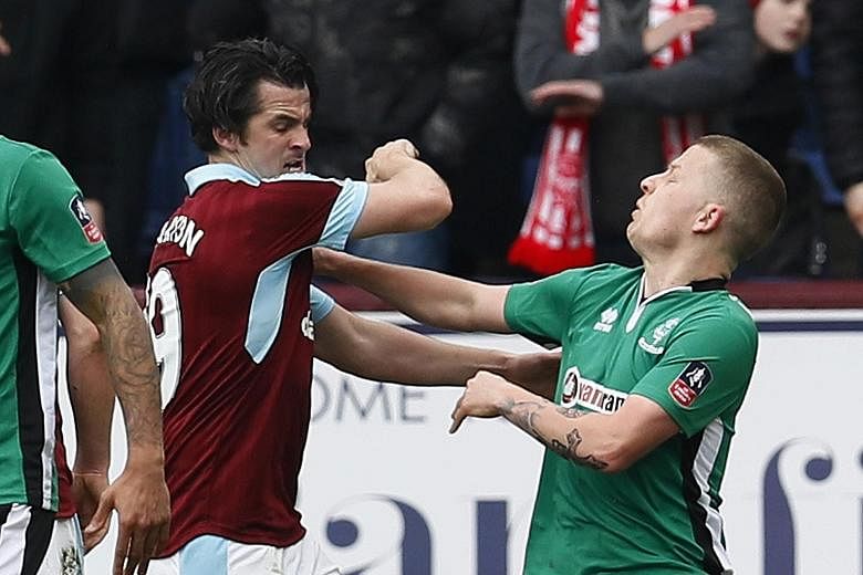 Above : Burnley midfielder Joey Barton clashes with Lincoln winger Terry Hawkridge at Turf Moor. 