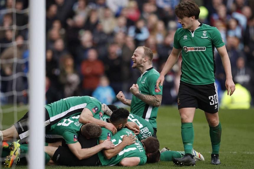 Above: Lincoln centre-back Sean Raggett celebrates his 89th-minute winner with his team-mates against a side 81 places higher up the English ladder. 