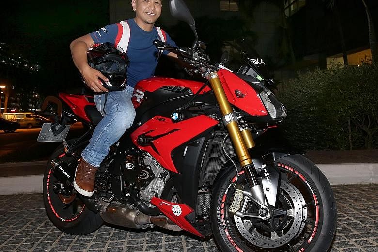 Aircraft engineer Muhammad Syahrul with his year-old BMW S1000R motorcycle, which cost him $30,000. The 29-year-old's plan to upgrade to a BMW R1200GS has been put on hold as the tiered ARF has caused the R1200GS to double in price, from $40,000 last