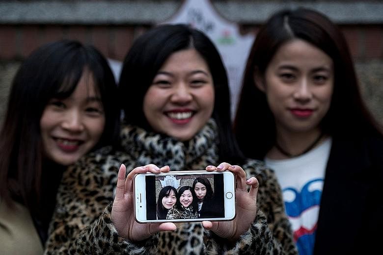 Ms Hu (far left) and her friends, Ms Wang Peng (centre) and Ms Peng Lin, with a selfie they took on Jan 8. Such virtual makeovers have propelled Meitu to the top ranks of downloads in China.