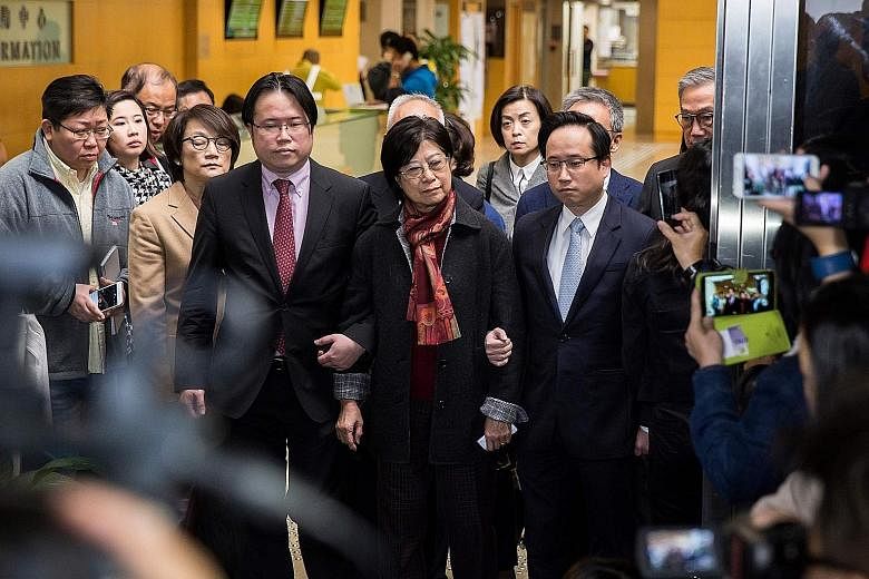 Tsang in a police van after sentencing. He failed to disclose a conflict of interest that arose when he was negotiating rent for an apartment with a landlord who was applying for a broadcasting licence. Mrs Tsang, flanked by her sons Simon (left) and