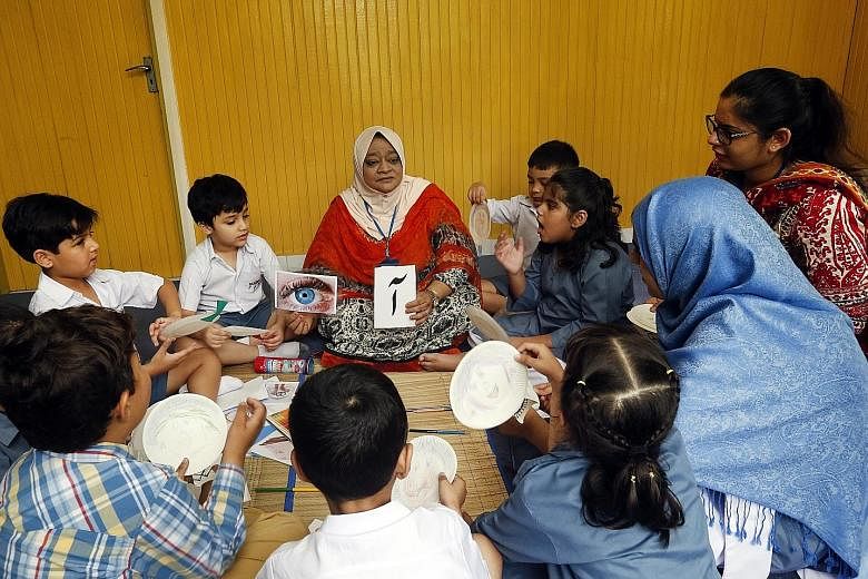 Hoping to keep the language alive here is Urdu Development Society Singapore educator Ahson Ara (centre), seen teaching a group of children.