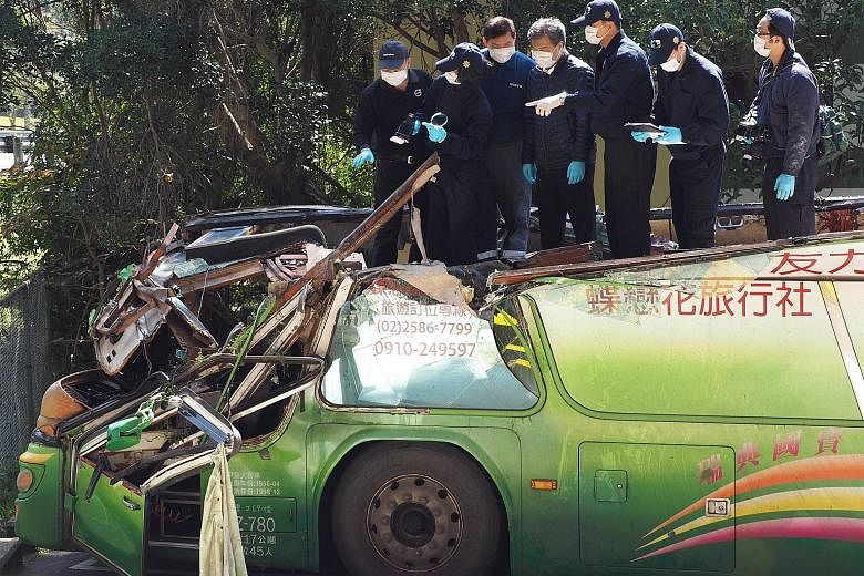 Investigators examining the wreckage of a tourist bus to try to find out the cause of the crash that killed 33 people and injured 11 in Taipei last week.