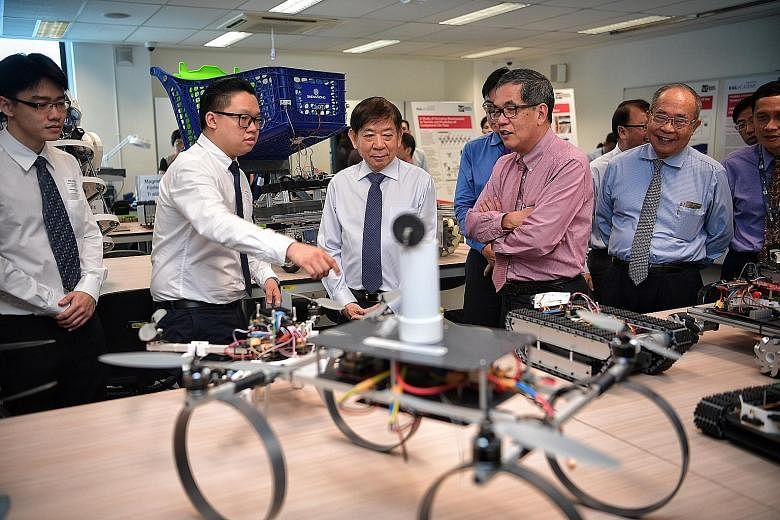 Mr Samuel Tan (second from left), 24, a second-year SIT student taking a Bachelor of Engineering with Honours in Systems Engineering course, showing Transport Minister Khaw Boon Wan (in blue tie) a series of student prototypes at the Systems Engineer
