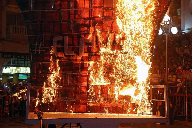 A fake wall being burned in a protest against Mr Donald Trump in the Mexican city of Veracruz. The US President may reallocate US aid to funds for a border wall.