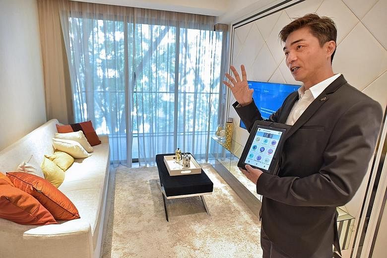 Mr Andrew Tan using a tablet to explain the "smart home" concept at the showflat for Fantasia Investment's 6 Derbyshire. Qingjian has also unveiled its "Internet-ready smart homes" at the iNz Residence EC (right).