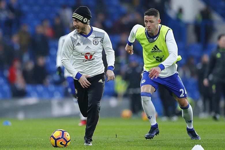 Eden Hazard (left) and Gary Cahill warming up before Chelsea's 2-0 win over Hull last month. The league leaders are looking hard to shake off.