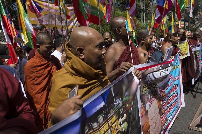 Myanmar Buddhist nationalists rallying outside the Thai Embassy in Yangon yesterday to protest against the Thai government's siege of the controversial Dhammakaya temple as officers search for an elderly monk - the temple's former abbot, Phra Dhammac