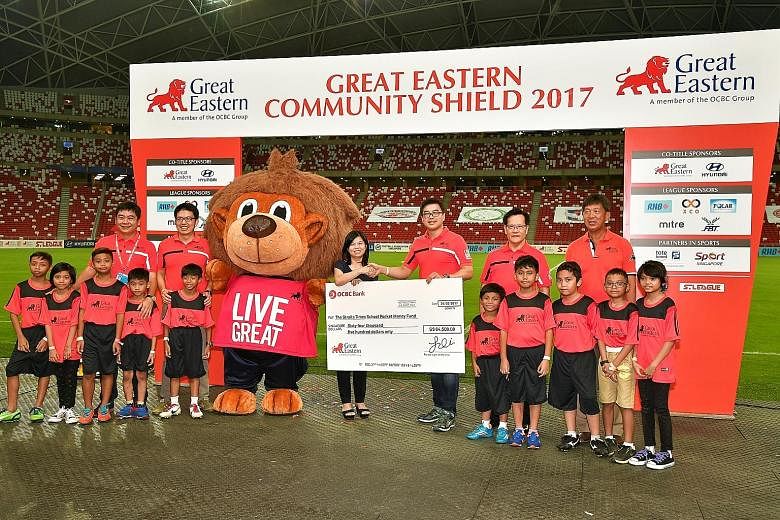 Above: Great Eastern managing director, life and regional bancassurance, Khoo Kah Siang presenting a cheque to Tan Bee Heong, general manager of The Straits Times School Pocket Money Fund, after the Community Shield match. Great Eastern, the S-League