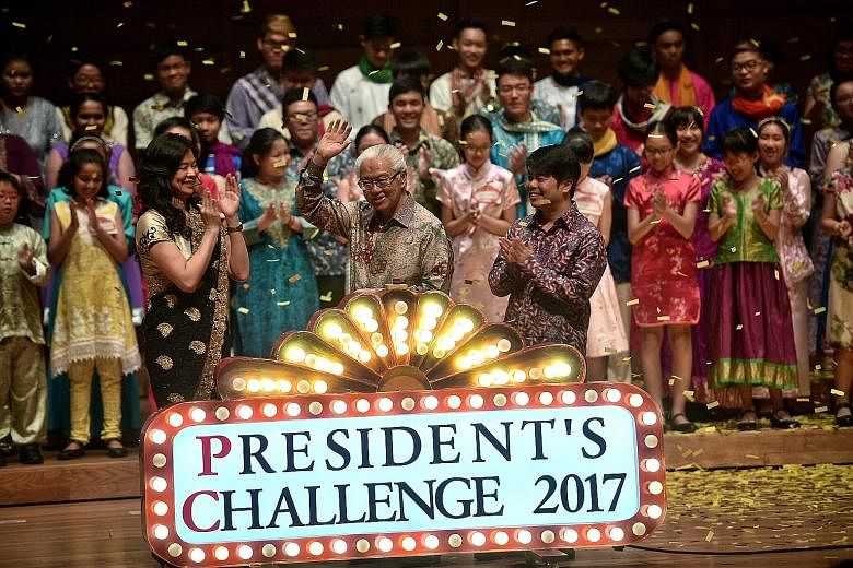 President Tony Tan Keng Yam being joined on stage by Mr Timothy Chionh, managing director of the Wild Empire Choral Group, and Ms Ong Chiak Yin, the choral conductor, during the launch of the President's Challenge yesterday. The annual campaign began