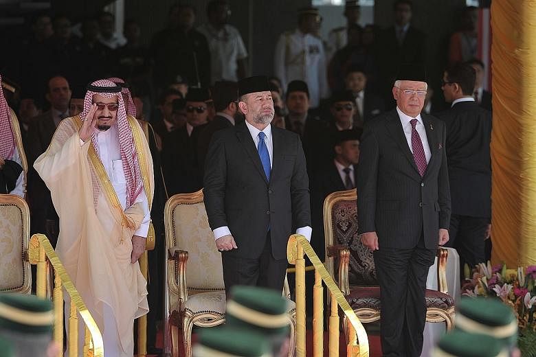 King Salman being welcomed at Malaysia's Parliament Square yesterday by Malaysia's King Muhammad V (centre) and Mr Najib.