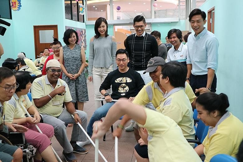 Actor Rayson Tan (seated, in black top) joins in a game with SPD beneficiaries. Looking on are celebrities (standing, from left): Michelle Tay, Xiang Yun, Ya Hui, Elvin Ng and Desmond Tan. Members of the SPD community will perform with celebrities du