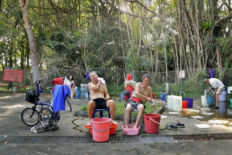 Visitors enjoy a relaxing foot soak (above and below) at the the hot spring. Some people wash their clothes there and regular visitors even padlock their buckets - and a metal bathtub - to the chain link fence. The hot spring sits in a military camp 