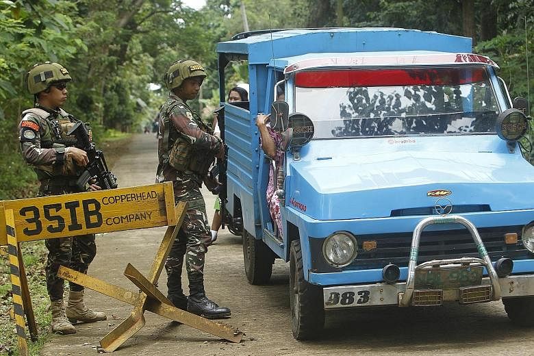 Philippine soldiers manning a checkpoint in Sulu yesterday. The province is home to the Abu Sayyaf, a group notorious for holding Filipinos and foreigners alike for ransom. Still, the Philippine Foreign Secretary says the country will stick to its to