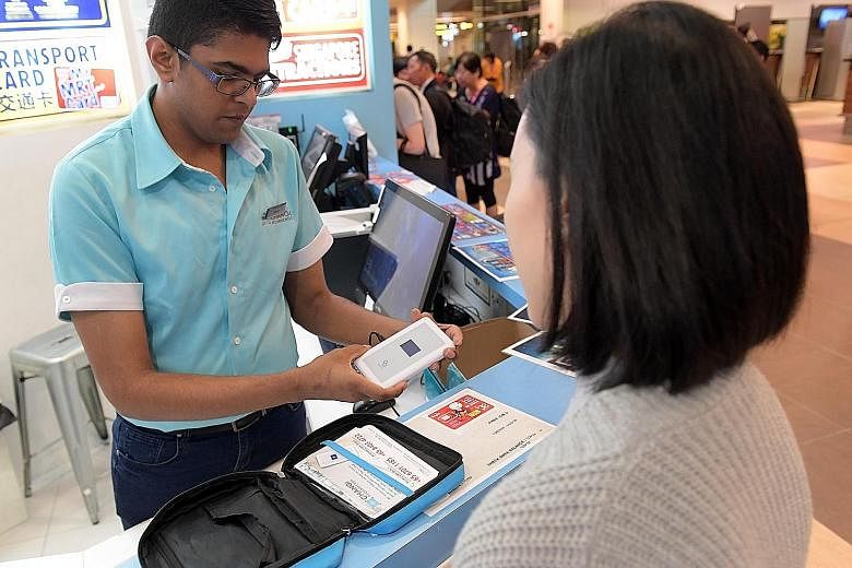 Above: Retail sales associate Jeryck Tan explaining to a customer how to use a Wi-Fi router at the Changi Recommends outlet in Terminal 1. The rental of such routers is a popular service that began in 2015. Left: There are eight Changi Recommends out