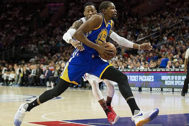 Golden State Warriors forward Kevin Durant outpaces Robert Covington of the Philadelphia 76ers during the 119-108 victory Durant led the Warriors with 27 points, while Klay Thompson contributed 21.