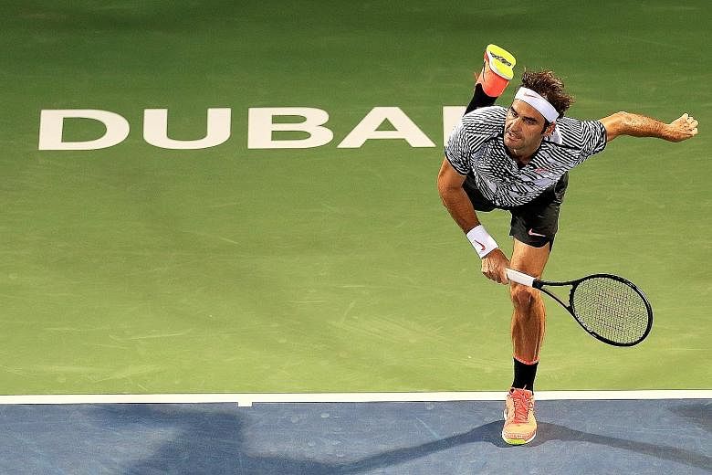 Roger Federer follows through on his serve during his 6-1, 6-3 victory against France's Benoit Paire at the Dubai Championships. The Swiss hopes to win his 19th Grand Slam title at Wimbledon.