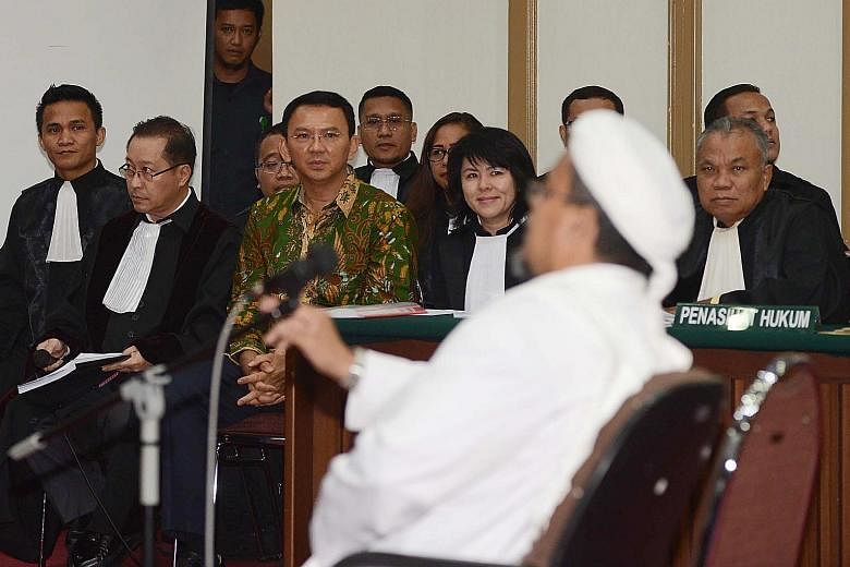 Mr Rizieq Shihab (in white) testifying as an expert witness on Islam during the blasphemy trial of Basuki Tjahaja Purnama (in green) yesterday.