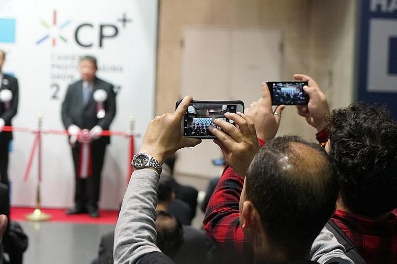 Reporters using their smartphones to take photos of the opening ceremony of CP+ Camera and Photo Imaging Show in Yokohama, Japan, last week. The camera market needs to be revolutionised.