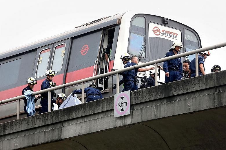 Singapore Civil Defence Force officers recovering the bodies of two trainees near Pasir Ris MRT station on March 22 last year, in what was SMRT's worst fatal rail incident.