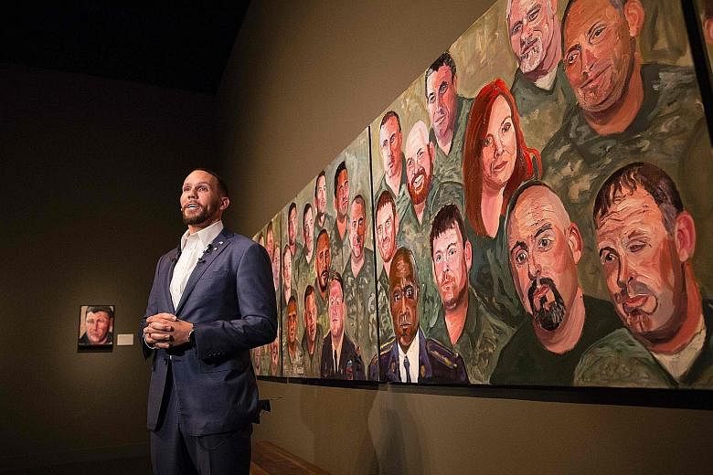 US Air Force Staff Sergeant Johnnie Yellock (right) in front of a painting of him by former United States president George W. Bush for the Portraits Of Courage exhibit at the George W. Bush Presidential Library and Museum in Dallas, Texas. On Tuesday