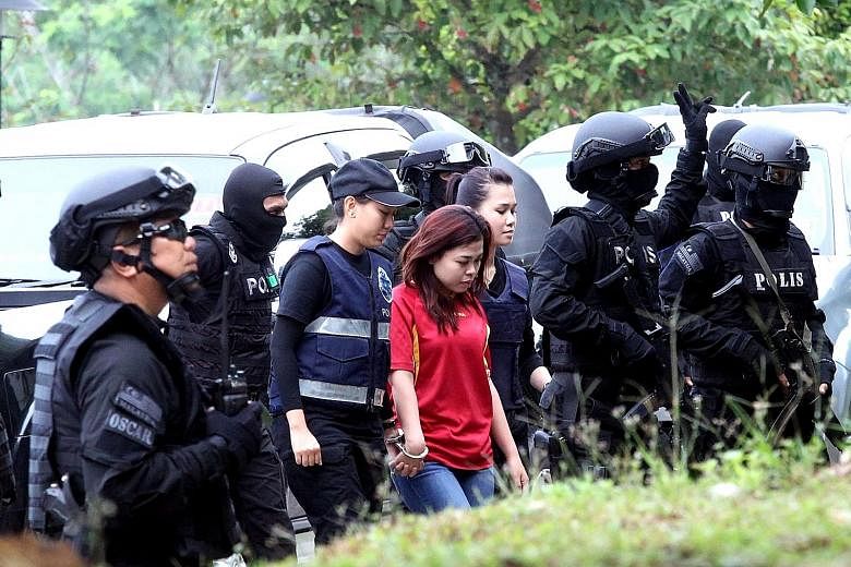 Indonesian suspect Siti Aisyah on her way to court in Sepang yesterday, where she and Vietnamese suspect Doan Thi Huong were charged with Mr Kim Jong Nam's murder.