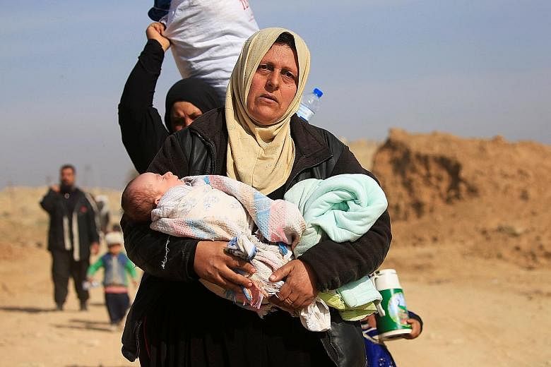 Displaced Iraqis fleeing from their homes during the Iraqi offensive against ISIS militants in Mosul yesterday.