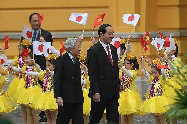 Children greeting Emperor Akihito (left) and Mr Quang at a welcoming ceremony at the presidential palace in Hanoi yesterday.