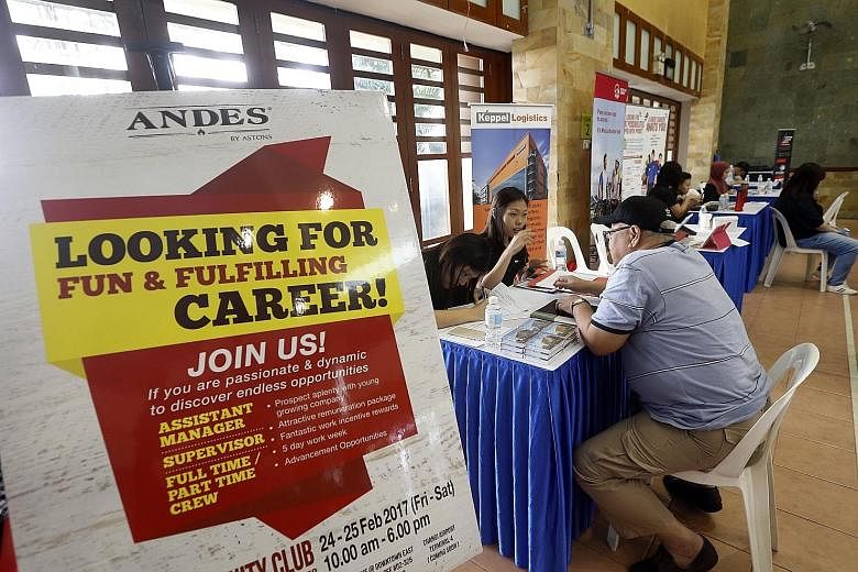 A job seeker being interviewed at a fair. To help workers pick up skills, NTUC will work with institutions to produce training modules relevant to employers.