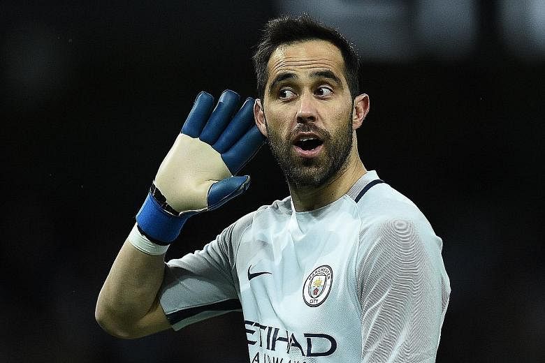 Sergio Aguero drilling past Huddersfield goalkeeper Joel Coleman to score Manchester City's fourth goal in the 73rd minute, taking his season tally to 22 goals in all competitions. Left: City goalkeeper Claudio Bravo gesturing to Huddersfield fans af