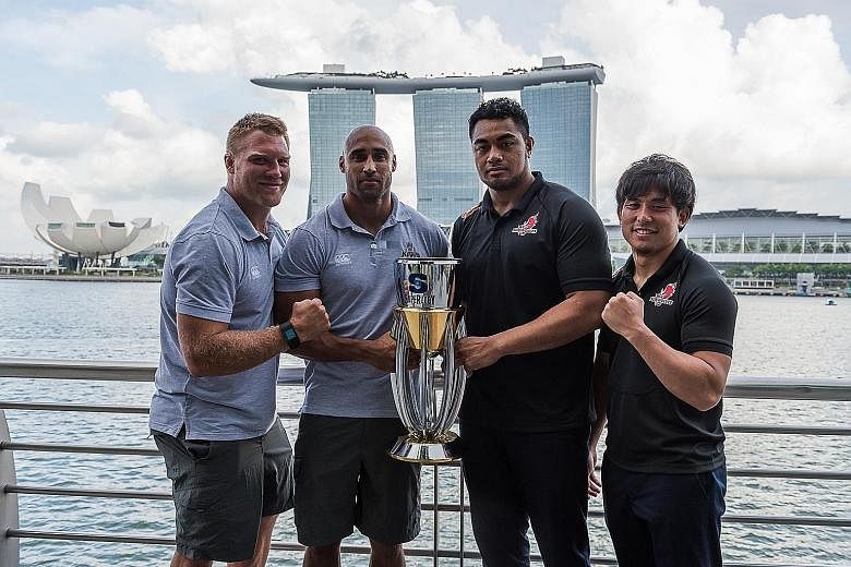 From left: Kings' Ross Geldenhuys and Waylon Murray as well as Sunwolves' Uwe Helu and Junpei Ogura pose with the Super Rugby trophy at One Fullerton yesterday. The two sides meet tomorrow at the National Stadium, the first of three matches that the 