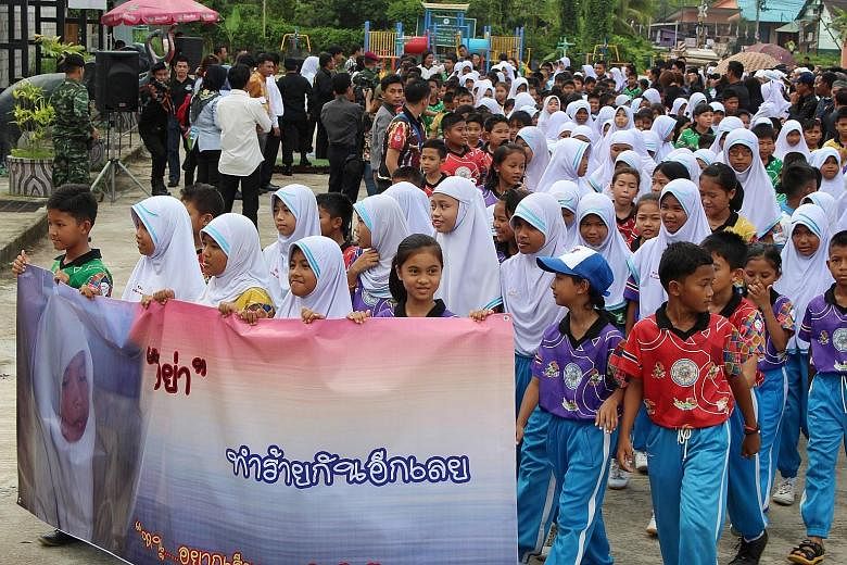 Children holding a banner reading "Stop hurting one another", during a rally for peace in Thailand's restive southern province of Narathiwat. More than 1,000 people marched in the insurgency-torn Thai south yesterday to condemn the killing of a Buddh